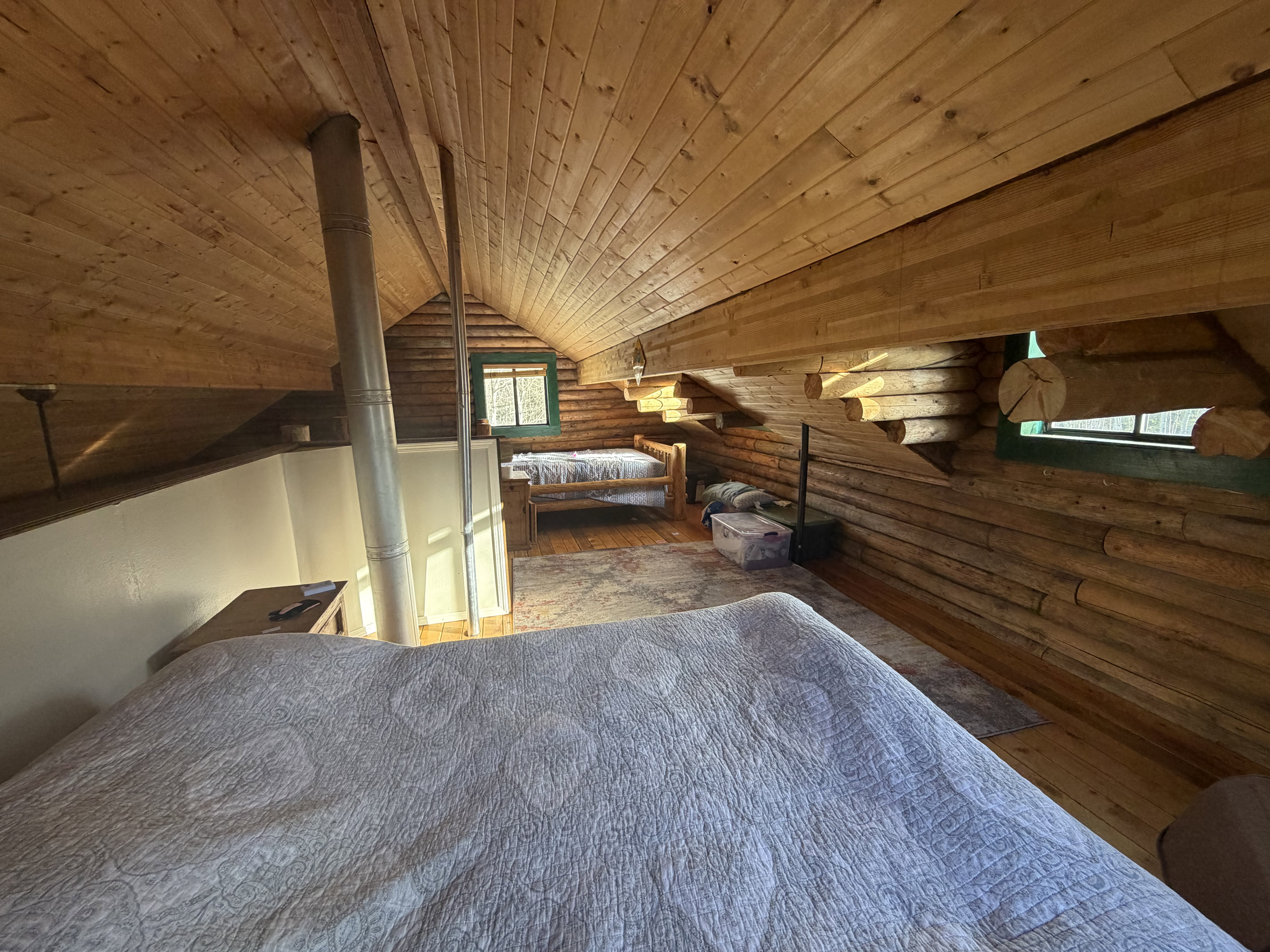 Bedroom featuring rustic walls, a vaulted wood ceiling, and hardwood / wood-style flooring