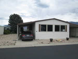 View of front facade with an attached carport s and concrete driveways.