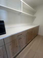 Custom built-in cabinetry with wood-finish doors, brushed brass hardware, and a light-toned countertop