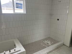Full bath featuring a bath and tiled shower