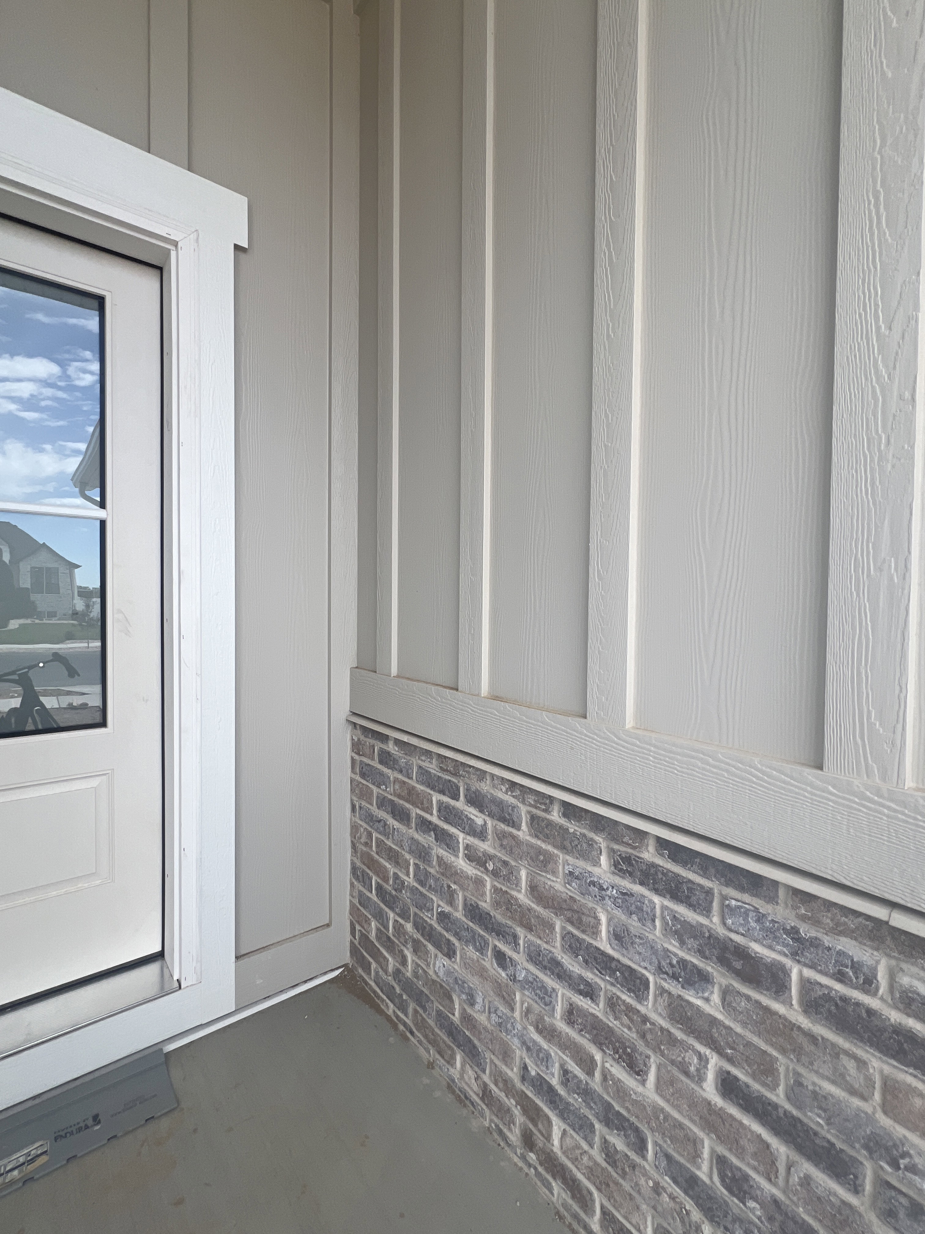 Exterior facade showcasing board and batten siding over a brick foundation