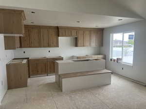 Kitchen with a kitchen island, wood finish cabinets, and a textured ceiling