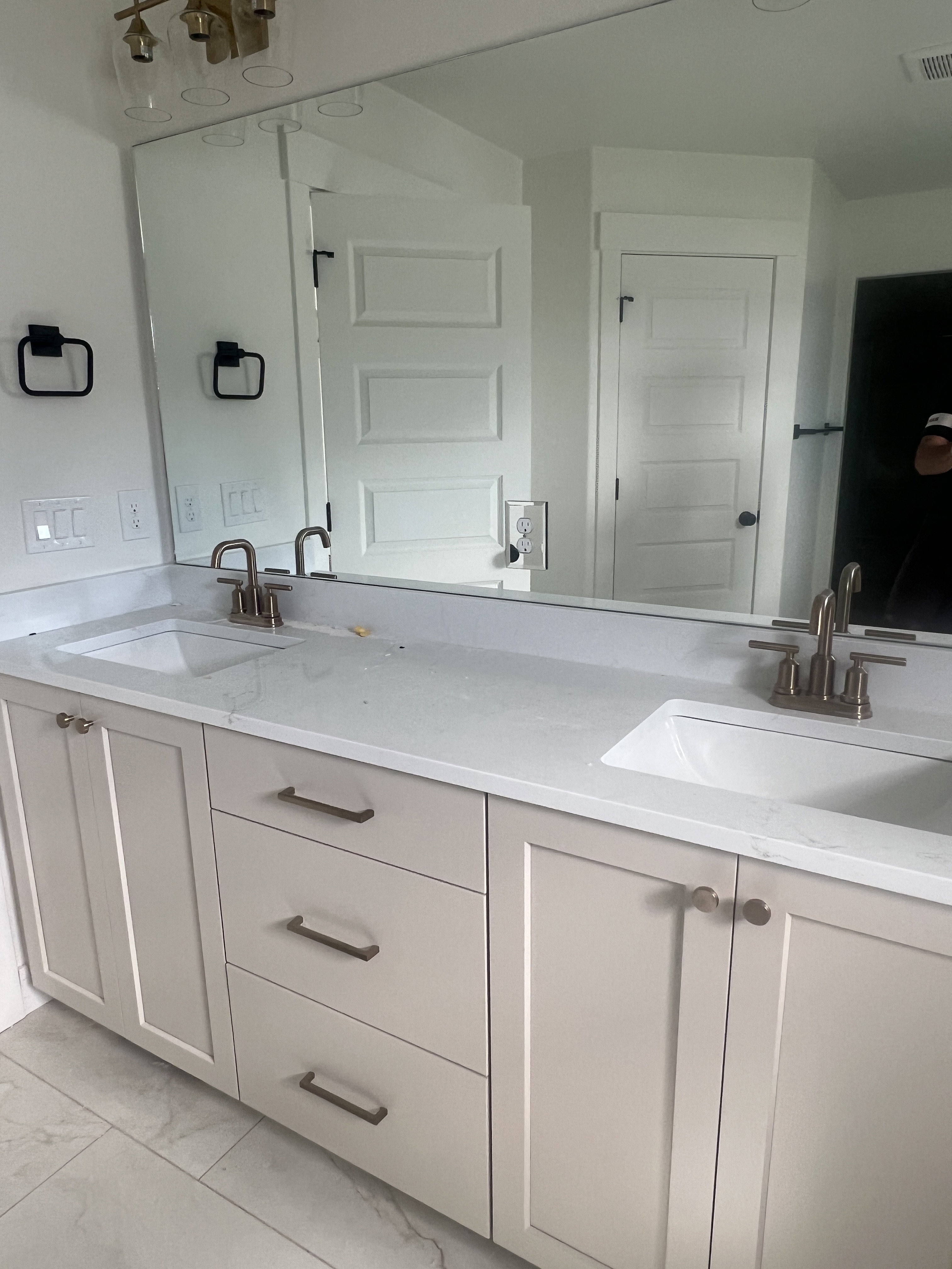 Dual vanity with light-colored cabinetry and stone-finish countertops