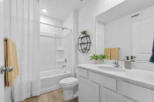 Full bath with light wood-style flooring, vanity, and shower / bath combo