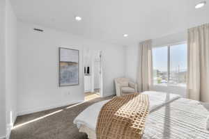 Bedroom featuring connected bathroom, light colored carpet, and recessed lighting