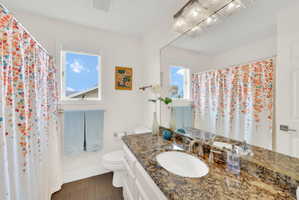 Bathroom with vanity, curtained shower, and dark floors
