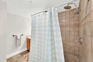 Bathroom featuring vanity, a shower stall, and light tile patterned floors