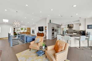 Living room with vaulted ceiling, hanging lights, and tile floors
