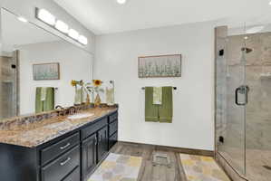 Bathroom with a stall shower, vanity, light tile floors, and recessed lighting