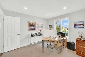 Office with light carpet and recessed lighting