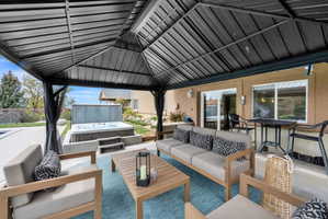 View of patio with an outdoor living space and a hot tub