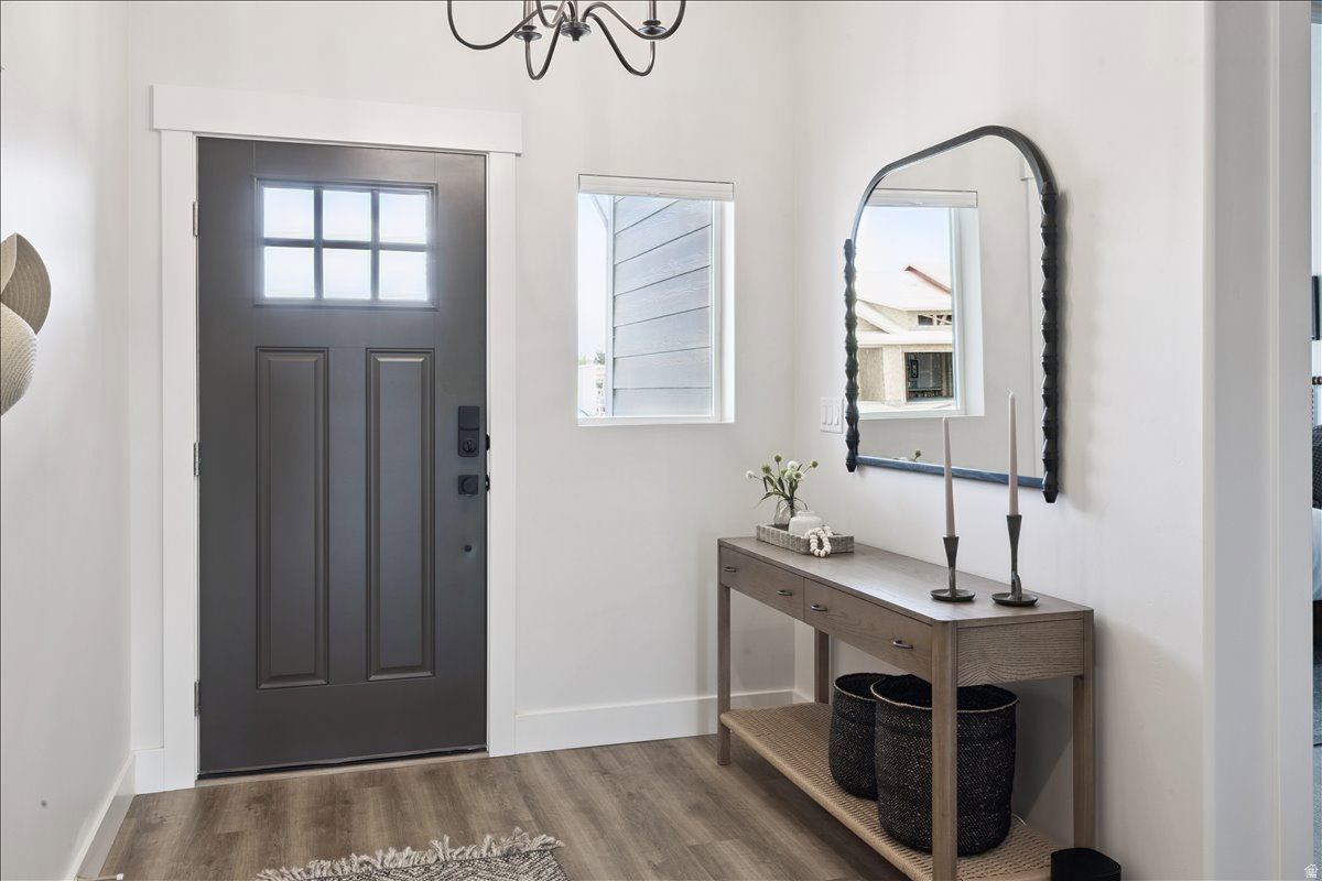Foyer entrance featuring wood finished floors and hanging lights