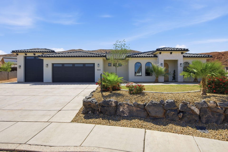 Mediterranean / spanish house featuring an attached garage, stucco siding, concrete driveway, and a tile roof