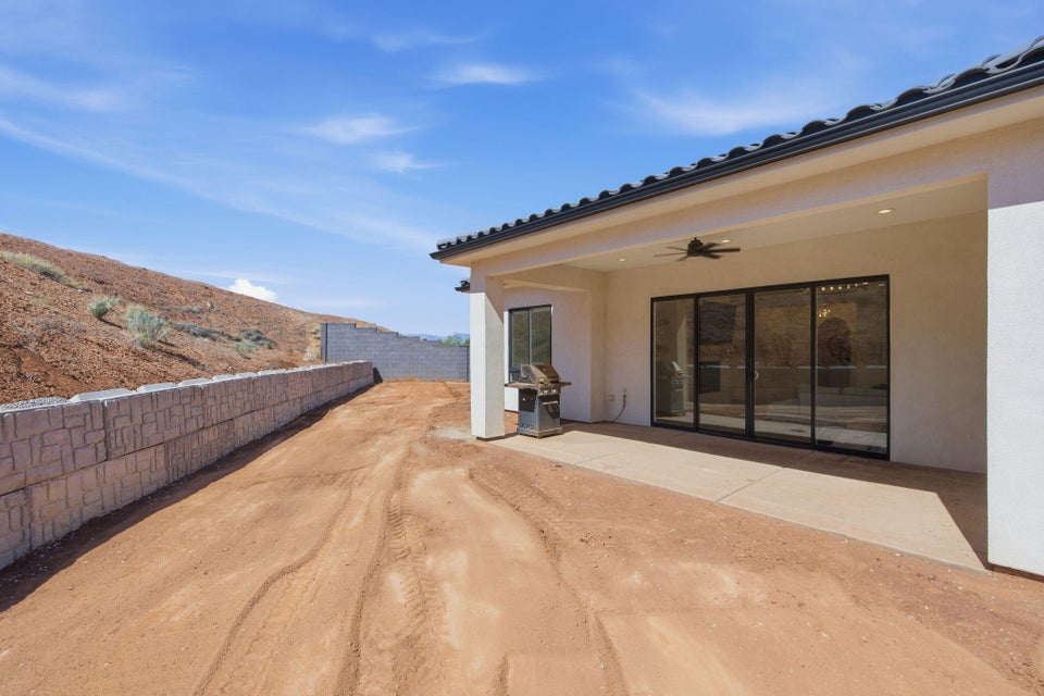 Fenced yard with a ceiling fan and a patio