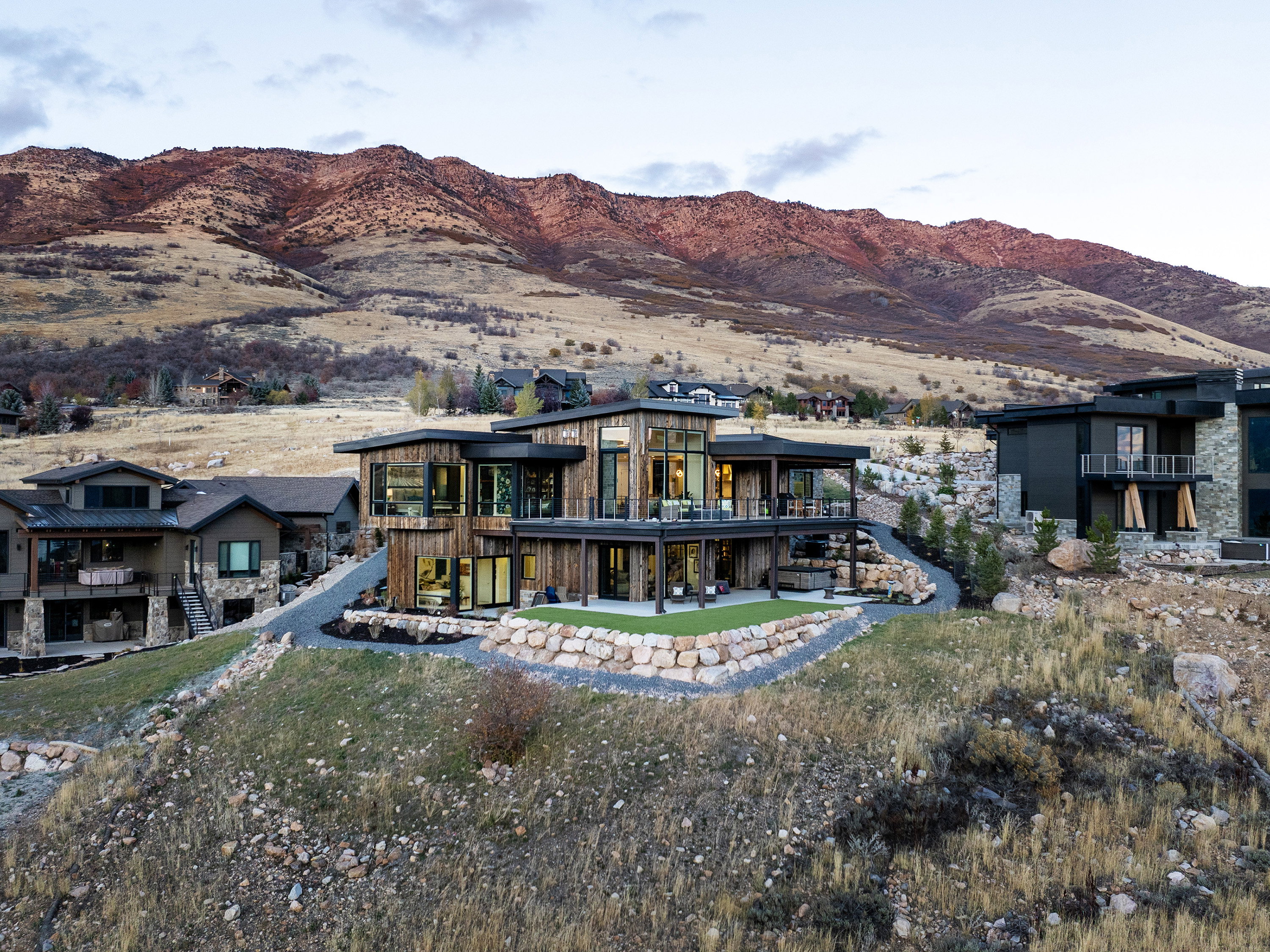 Back of property with a mountain view, a balcony, and a patio area