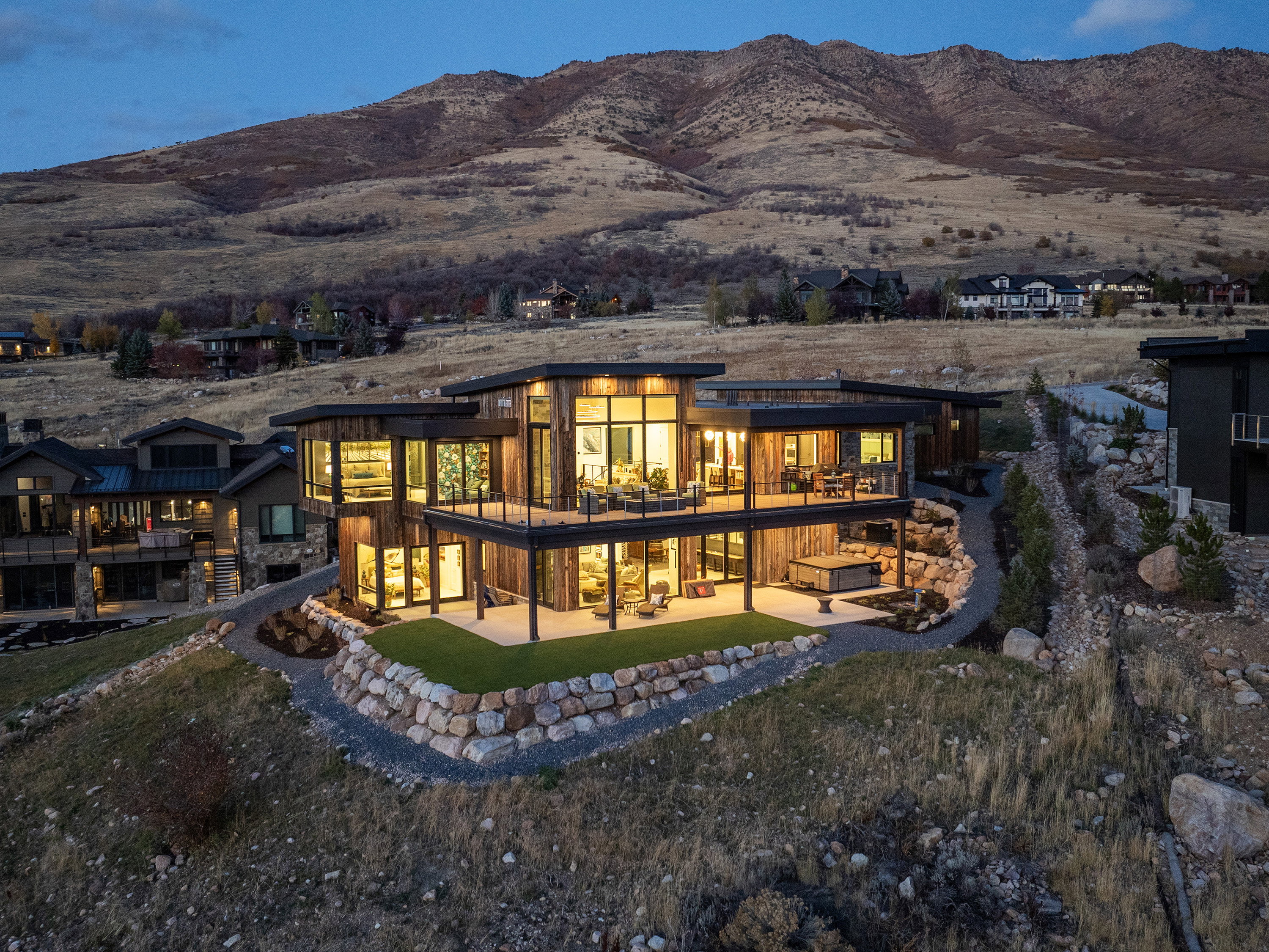 Rear view of house with a patio, a mountain view, and a lawn