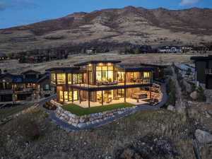 Rear view of house with a patio, a mountain view, and a lawn