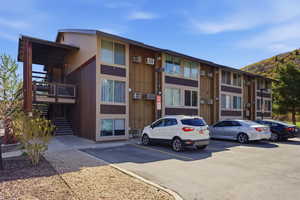 View of apartment building / complex with uncovered parking and a mountain view