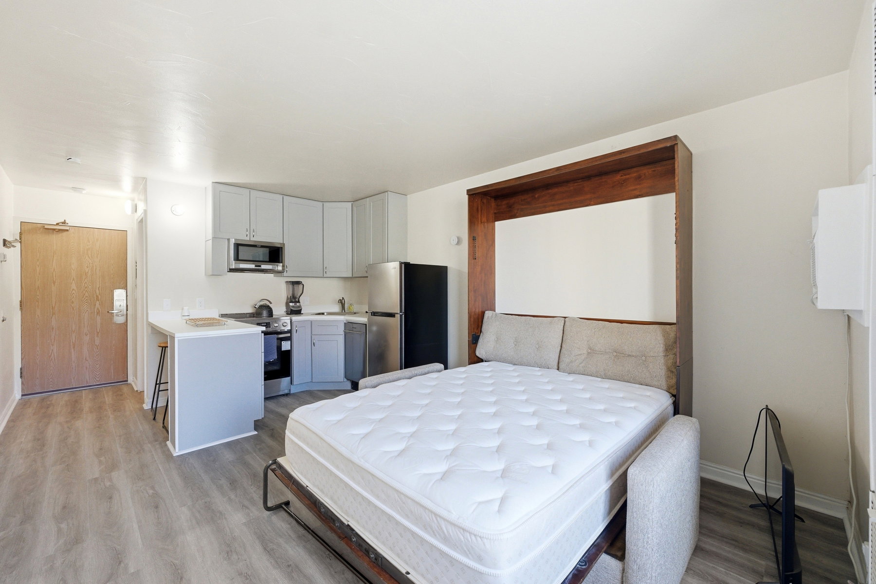Bedroom featuring freestanding refrigerator and light wood-style floors