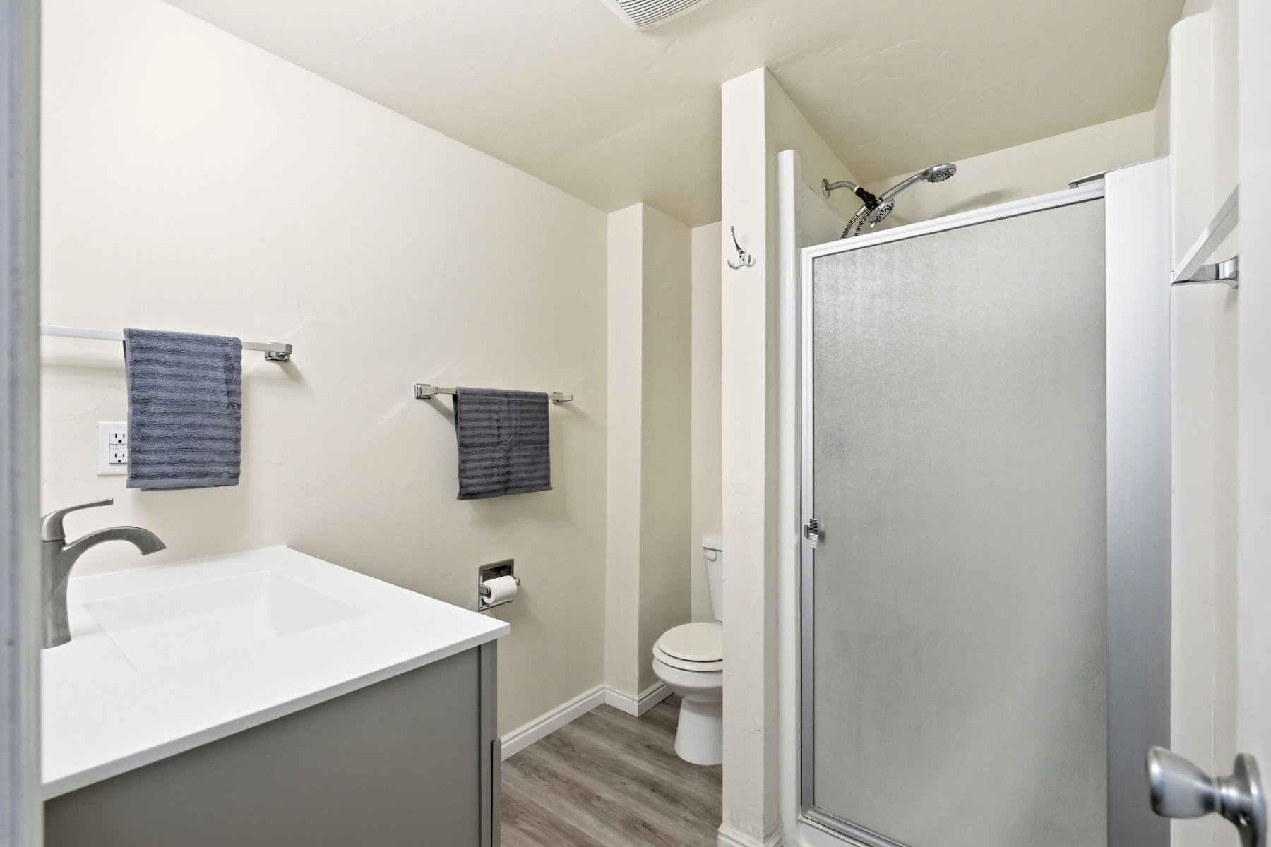 Full bathroom with a stall shower, vanity, and light wood-type flooring