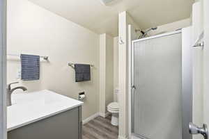 Full bathroom with a stall shower, vanity, and light wood-type flooring