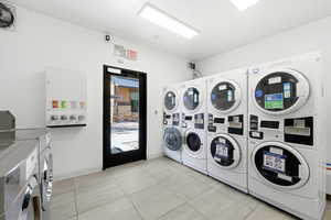 Communal laundry room featuring washing machine and clothes dryer and stacked washer / drying machine