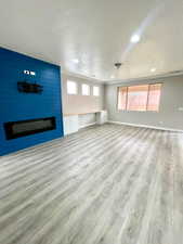 Unfurnished living room featuring a fireplace, light wood-style flooring, ornamental molding, and recessed lighting