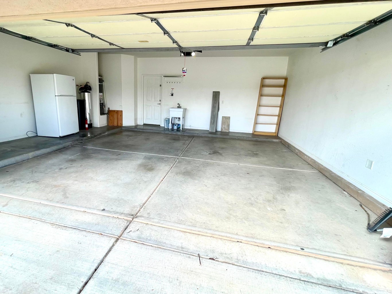 Garage with freestanding refrigerator and water heater