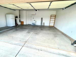 Garage with freestanding refrigerator and water heater