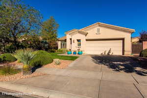 View of front of property with a garage, stucco siding, and concrete driveway