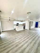 Unfurnished living room featuring light wood-style floors, crown molding, and recessed lighting