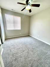 Empty room featuring carpet floors and ceiling fan