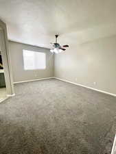 Spare room with carpet flooring, a textured ceiling, and a ceiling fan