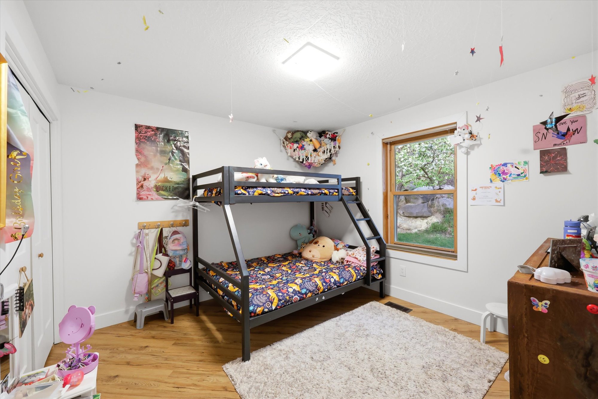 Bedroom featuring light wood-style floors, a textured ceiling, and a closet