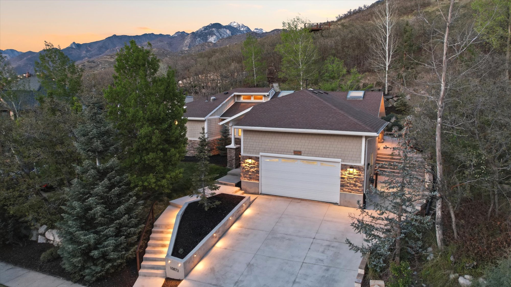 View of front of home with a mountain view, driveway, a shingled roof, and a garage