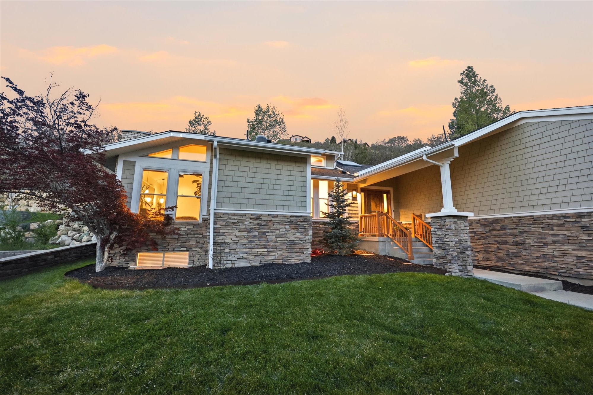 View of front of home featuring stone siding and a front lawn