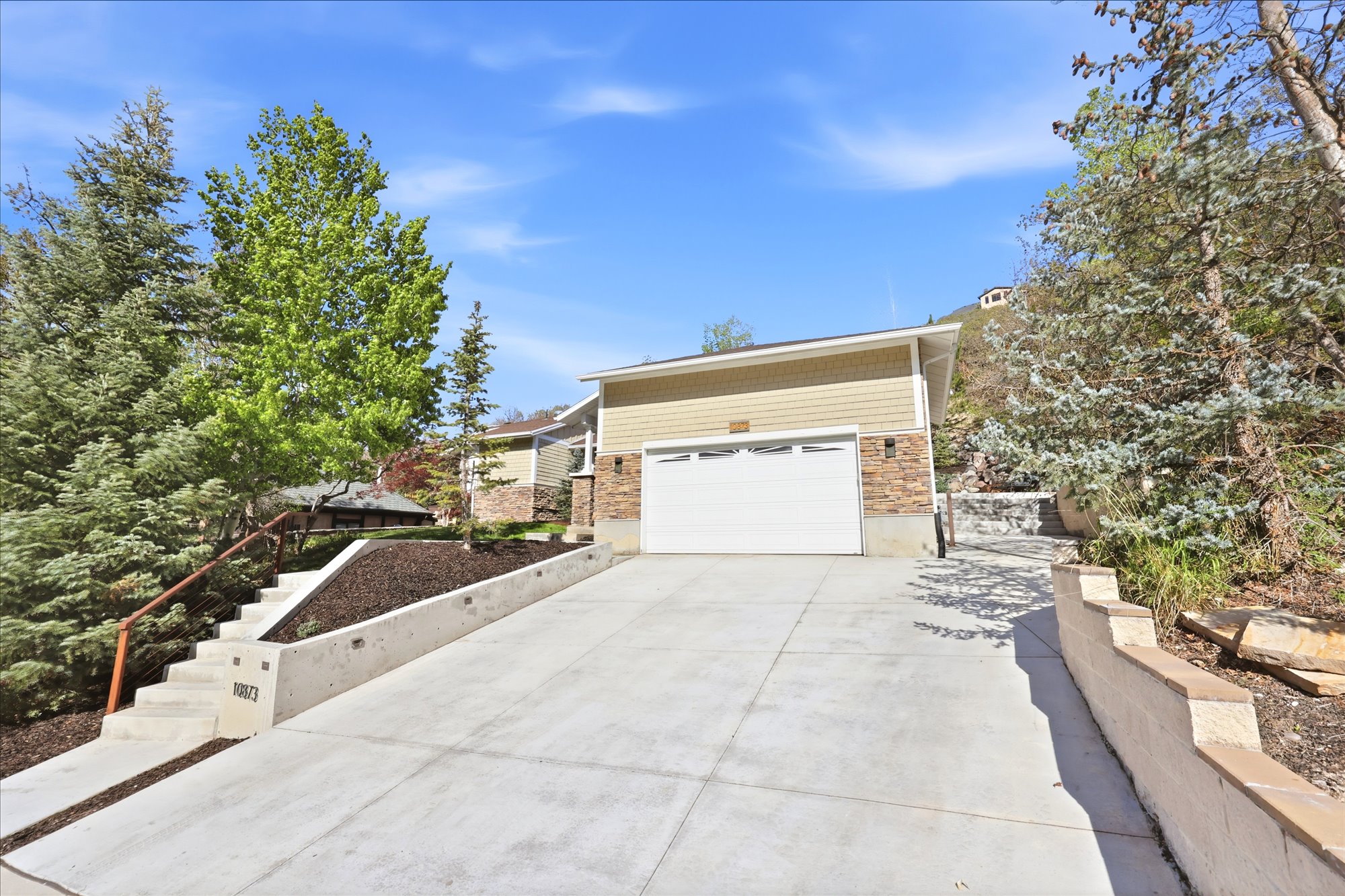View of front of property with concrete driveway and an attached garage