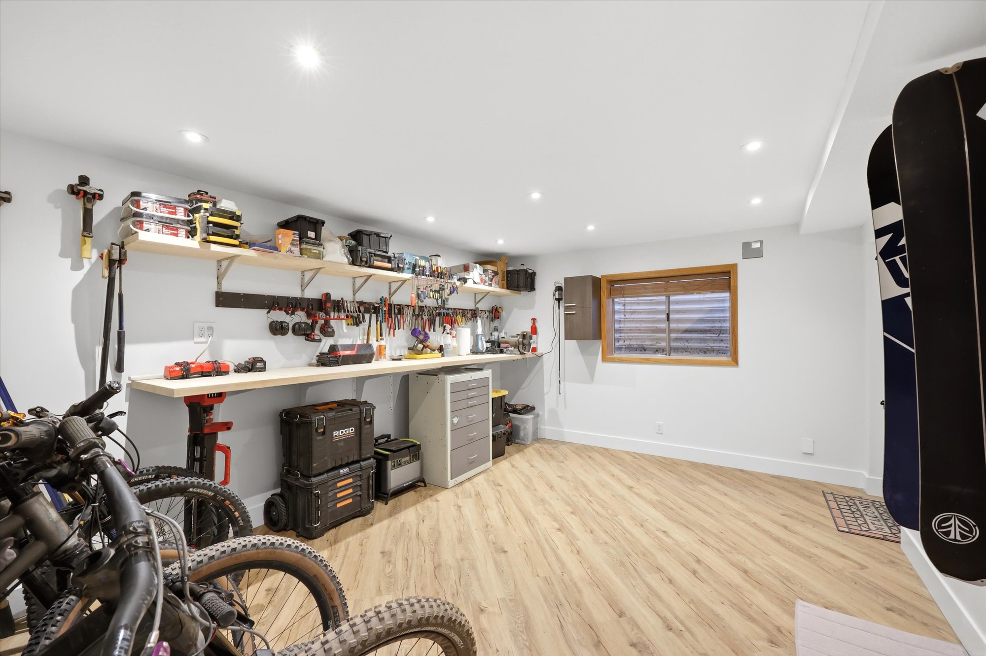 Misc room featuring light wood-style floors, recessed lighting, and a workshop area