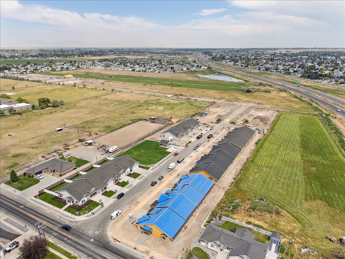 Aerial view of property and surrounding area featuring nearby suburban area and a large body of water
