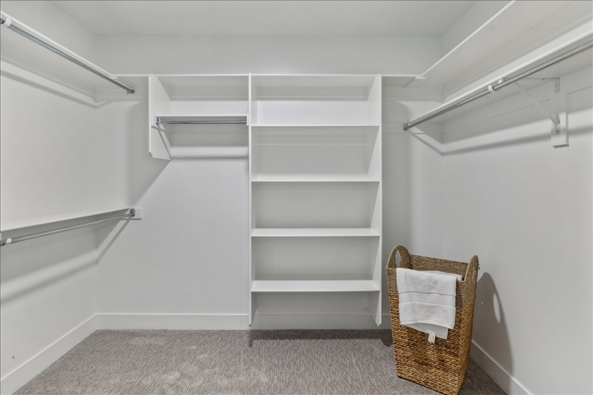 Walk in closet featuring light carpet