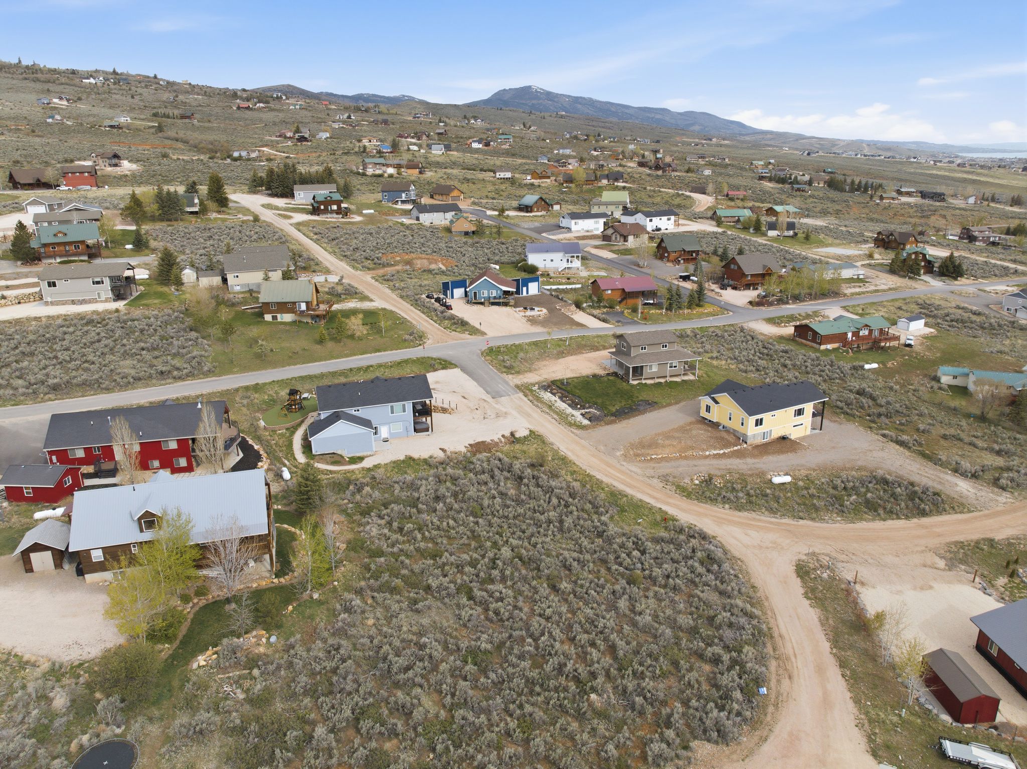 Aerial view of property and surrounding area with nearby suburban area and a mountainous background