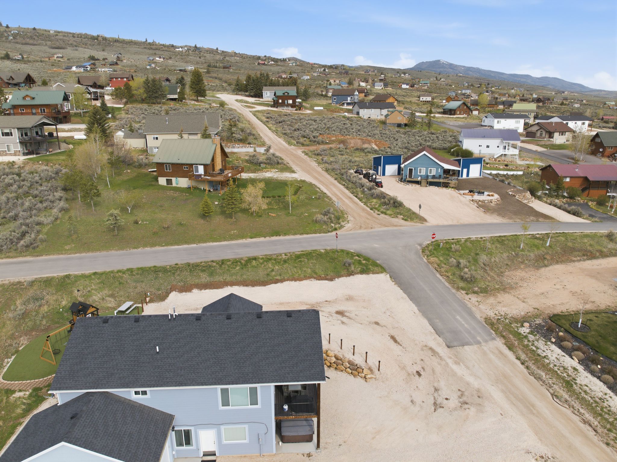 Aerial view of property's location with nearby suburban area and a mountainous background