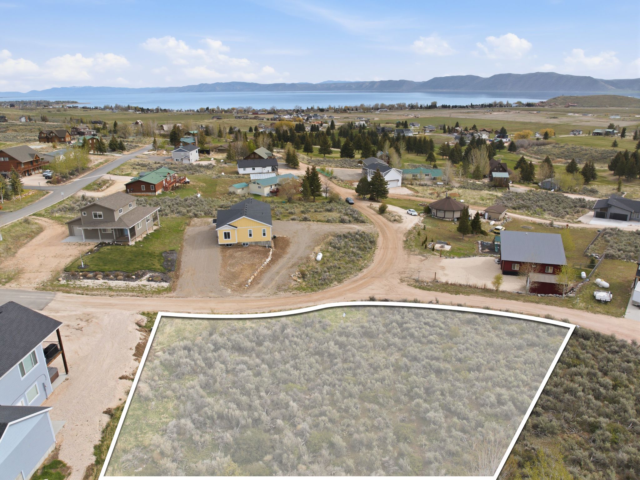 Aerial view of residential area with a mountainous background and property boundaries highlighted