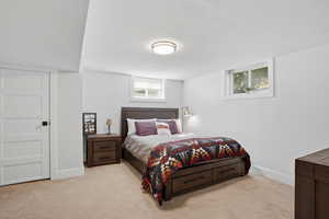 Bedroom featuring light colored carpet and a textured ceiling