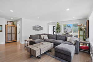 Living area with wood finished floors and recessed lighting