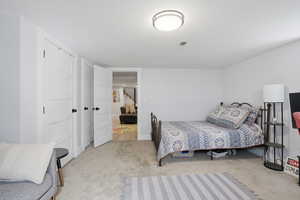 Bedroom featuring light carpet and baseboards