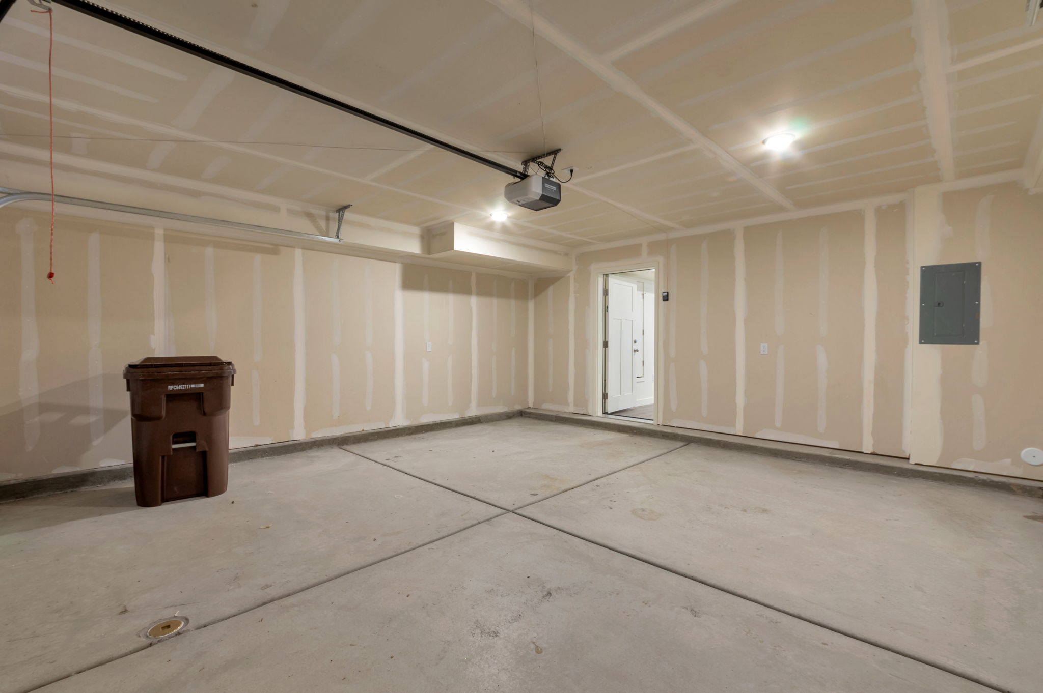 Garage with electric panel and a garage door opener