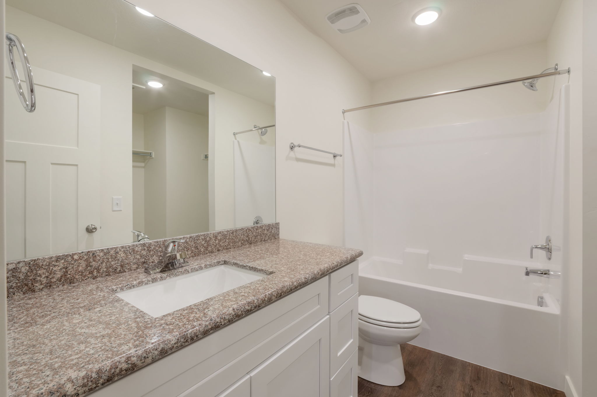 Bathroom with vanity, shower / tub combination, and dark wood-style floors
