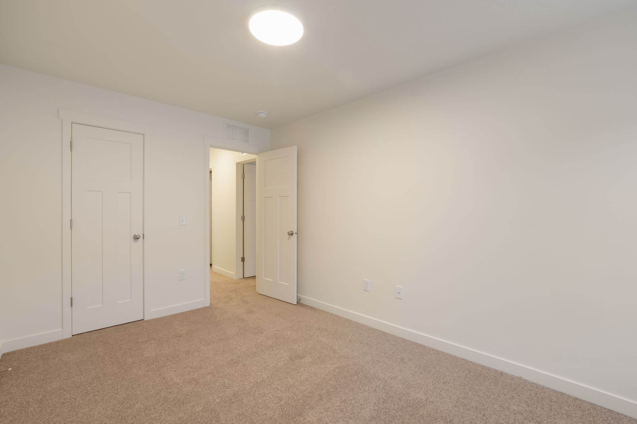 Unfurnished bedroom with baseboards and light carpet