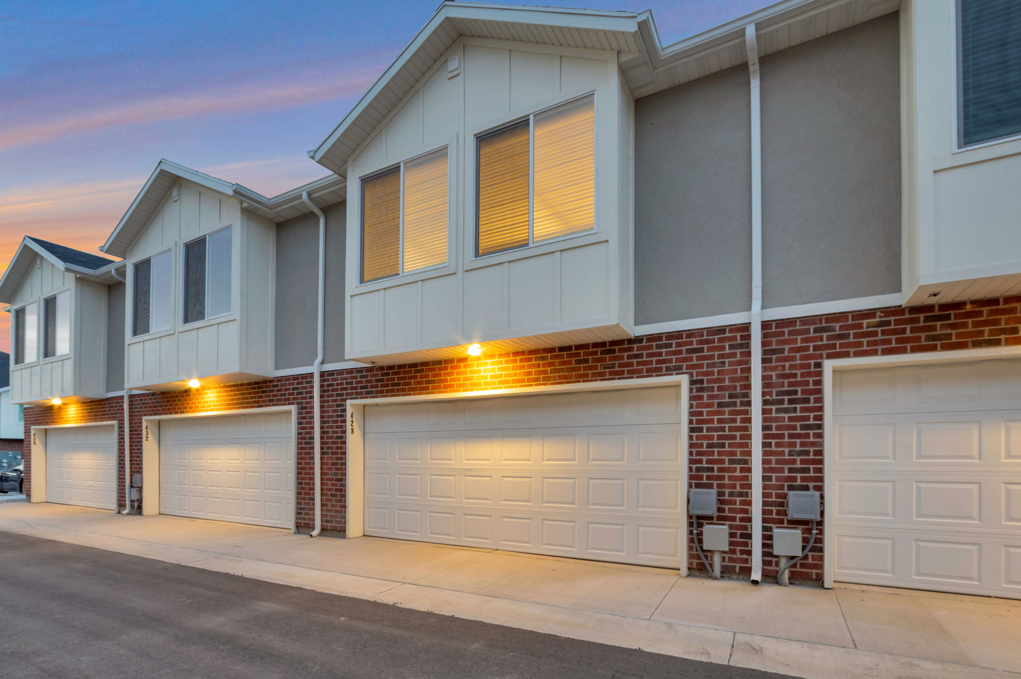 View of front of home featuring board and batten siding, an attached garage, and brick siding